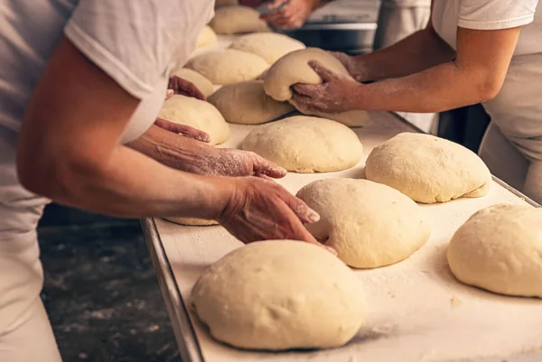 Bakers forming bread dough in a bakery. Bakery Concept.