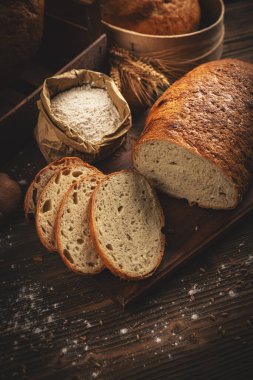 Concept of traditional sourdough bread on dark wooden background clipart