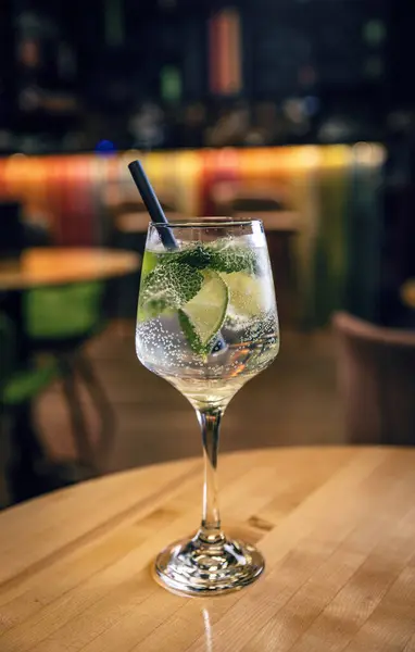 Alcohol drink, gin tonic cocktail with lime served whit drinking straw
