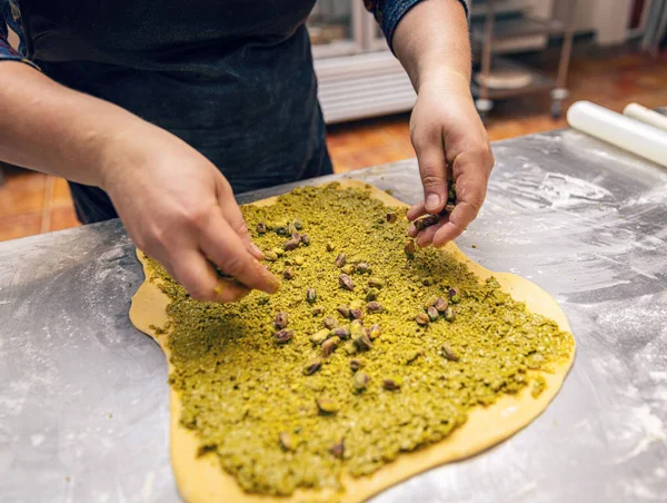 Bakery process. Preparing sweet roll or babka with pistachio cream