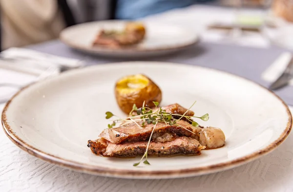 레스토랑 테이블에 접시에 감자와 쇠고기 스테이크 — 스톡 사진