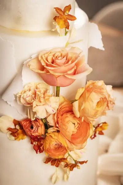 Close up of beautiful wedding cake with peach fuzz colored flower