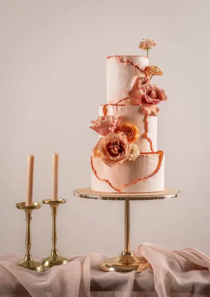 Beautiful wedding cake decorated with peach fuzz colored flowers