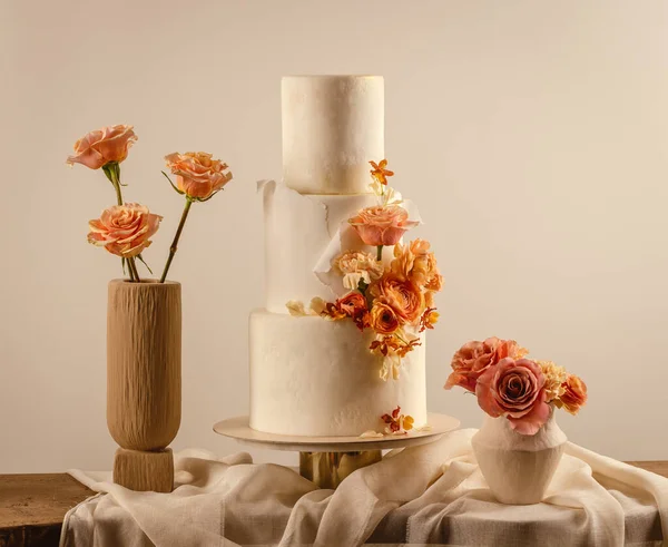 Beautiful wedding cake decorated with peach fuzz colored flowers
