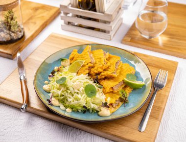 Lokanta masasında marul ve menü konsepti olan lezzetli sosisli şnitzel.