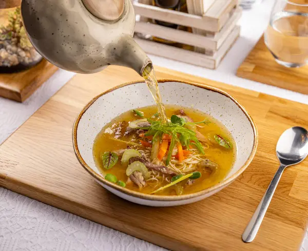 Garçom Derrama Caldo Uma Sopa Frango Com Macarrão Carne Legumes Imagens Royalty-Free