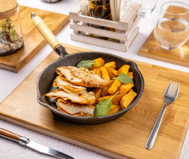 Homemade breaded pork chop stuffed with cheese served with french fries