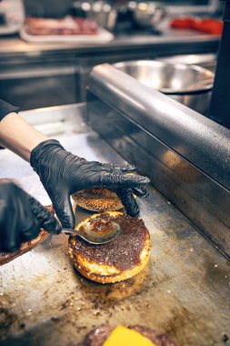 Hamburger pişirme işlemi. Şef hamburger yapıyor..