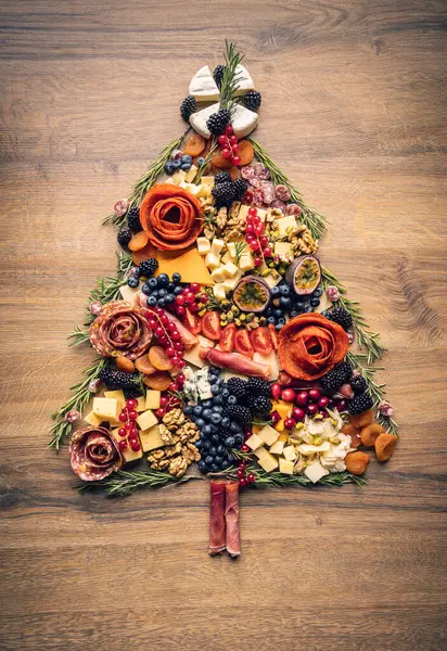 肉の選択 ソーセージを切断し クリスマスツリーの形でチーズや果物で肉を治しました ストック画像