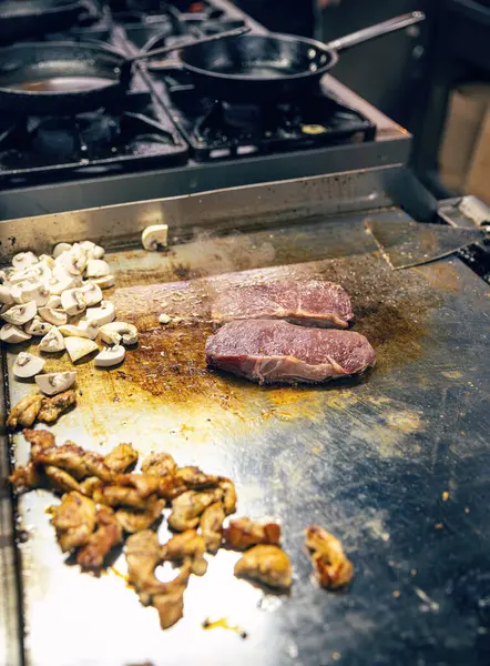 餐厅厨房概念 肉类和蘑菇烤在餐厅烤盘上 图库图片