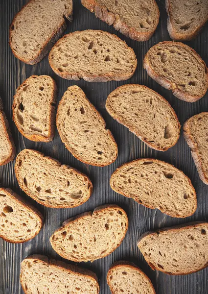 Horní Pohled Různé Plátky Rustikálního Celozrnného Chleba Úhledně Uspořádaného Tmavém — Stock fotografie