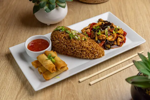 スプリングロールと米の美味しいアジア料理のプラッター ストック写真