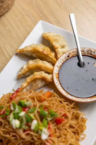 白盘上的炒面 饺子和肉酱 亚洲菜的概念 图库图片