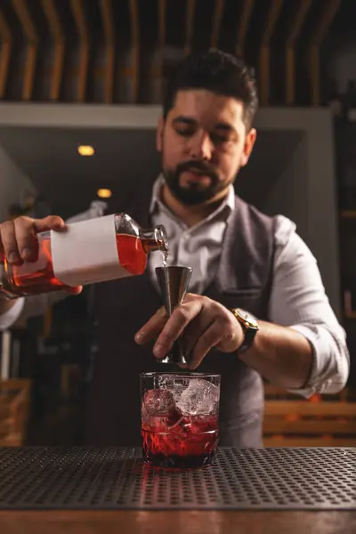 Geschickte Männliche Barkeeper Gießt Sorgfältig Einen Lebendigen Roten Cocktail Durch Stockbild