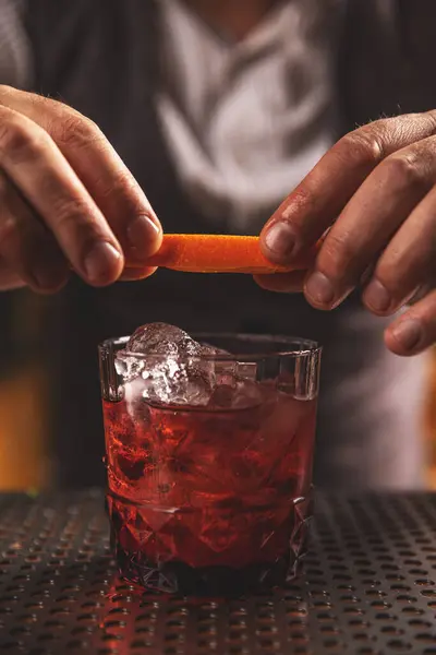 Close Das Mãos Barman Enfeite Coquetel Vibrante Com Uma Torção Fotografia De Stock