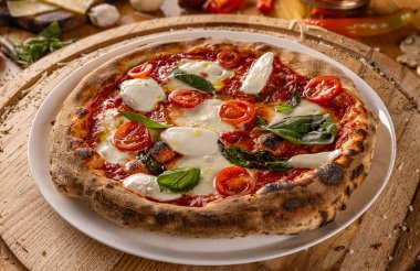 İtalyan pizzası, mozarella ve fesleğenle süslenmiş taze domates. 