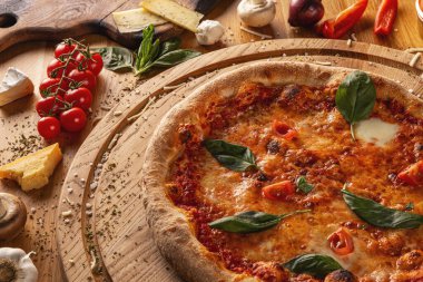 İtalyan pizzası Margherita peynirli, domates soslu ve fesleğenli ahşap tahtada