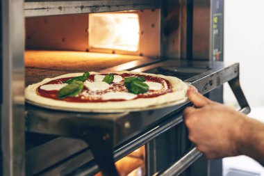 Fırına taze pizza konuldu.