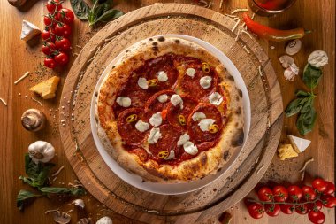 Köy ahşap sehpasında sergilenen taze malzemeli nefis biberli pizza.