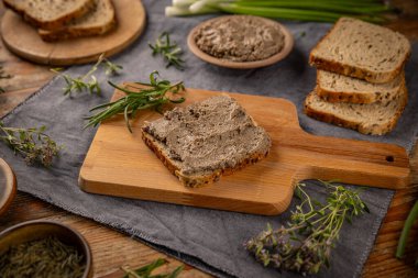 Lezzetli ev yapımı karaciğer ezmesi, ekmek ve otlar kırsal masada.