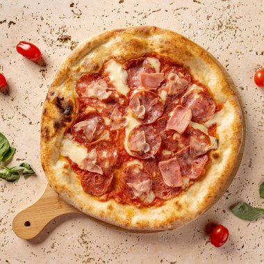 Yuvarlak, pepperonili ve jambonlu pizza, servis etmeye hazır.