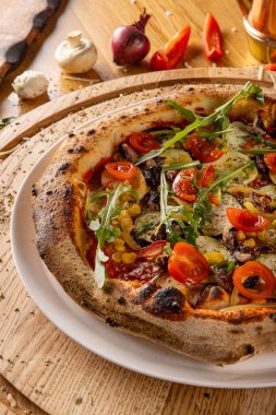 Ahşap arka planda sebzeli lezzetli vejetaryen pizzası.