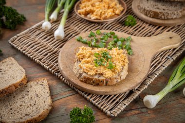 Yumurta soslu tam buğday tostu ve ahşap tahtada soğan, sağlıklı ve lezzetli bir kahvaltı veya atıştırmalık için mükemmel.