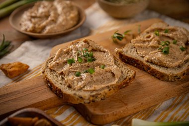 Tahtanın üzerinde iki dilim ekmek ve yeşillik var.