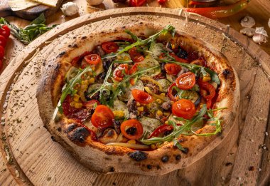 Fırında pişmiş lezzetli vejetaryen pizzası ahşap kesim tahtasında.