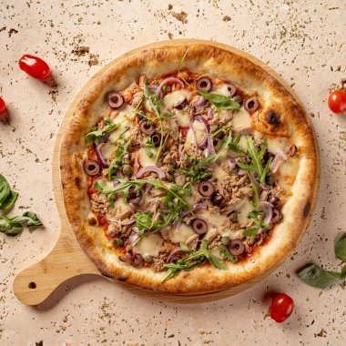 Lezzetli ton balıklı pizza Travertine masasında ahşap tahtada yatıyor