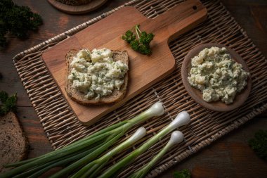 Yeşil soğanlı patates salatası ve bir dilim ekmeğin üzerinde maydanoz.