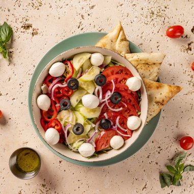 Nefis taze salata, mozarella, domates, salatalık, zeytin ve bir tabak pide ile servis edilir.