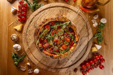 Taze vejetaryen pizzası. Taze malzemelerle çevrili.