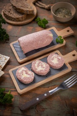 Maydanoz ve çavdar ekmeğiyle dilimlenmiş yumurta dolgulu jambonlu sosis.