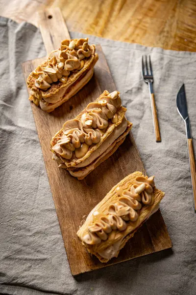 Fıstık ezmesi kremalı lezzetli Mille Feuille hamur işleri ahşap tahtada duruyor.