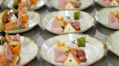 Mutfak çalışanları yemek servisi için aperatifler hazırlar.