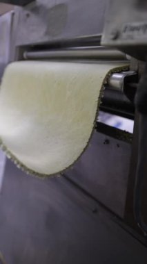 Makarna hamuru bir makarna fabrikasında endüstriyel patinajcılar tarafından düzleştirilir.