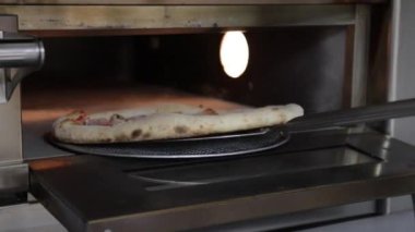 Profesyonel aşçı jambonlu pizza pişiriyor ve elektrikli fırında mozzarella pişiriyor.