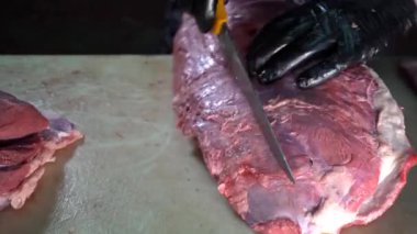 Kasap eti ayırıp kesiyor.