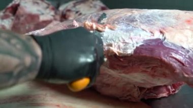 Kasap et kesiğindeki zarları çıkarıyor.