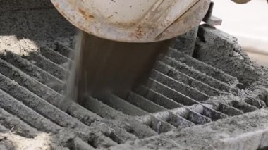 Beton karıştırıcı kamyondan metal ızgaraya ıslak beton dökülüyor.