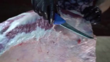 Profesyonel kasap et etinden bıçak kullanarak zar çıkarıyor.