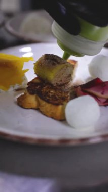 Şef son dokunuşu yapıyor, restoranın mutfağında başlangıç tabağını dekore ediyor.