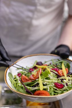 Profesyonel şef canlı bir salataya son rötuşları ekliyor.
