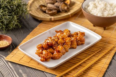 Ballı susam tavuğu pilavla servis edilir.