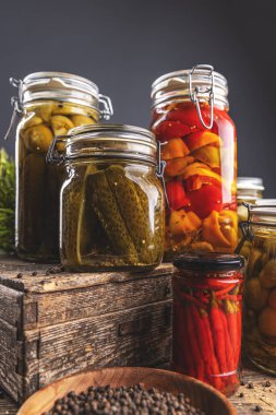 Cam kavanozlarda turşu çeşitleri gösteren korunmuş sebzeler.