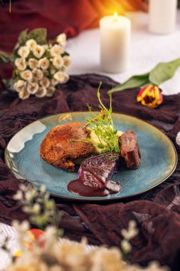 Lezzetli kavrulmuş ördek konservesi kremalı patates püresi, haşlanmış kırmızı lahana ve zengin böğürtlen sosuyla servis edilir.