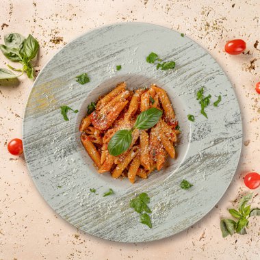 Köy tabaklarında servis edilen domates soslu, peynirli, fesleğenli ve baharatlı makarna cezbedici bir aşçılık sahnesi yaratır.