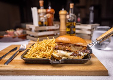 Restoran ortamında sıcak tavada servis edilen kibrit çöplü lezzetli kaz ciğeri burgeri.