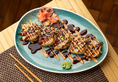 Tempura maki suşi sarması, wasabi, zencefil ve sosla servis edilir.